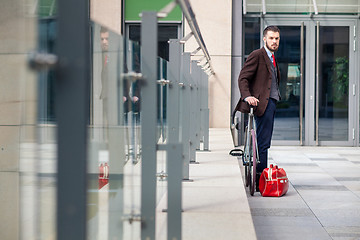 Image showing Handsome businessman and his bicycle