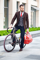 Image showing Handsome businessman and his bicycle