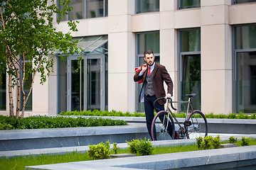 Image showing Handsome businessman and his bicycle