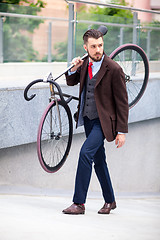 Image showing Handsome businessman carrying his bicycle