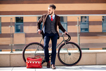 Image showing Handsome businessman and his bicycle