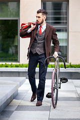 Image showing Handsome businessman and his bicycle