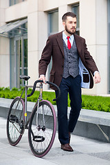 Image showing Handsome businessman and his bicycle