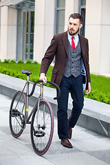 Image showing Handsome businessman and his bicycle