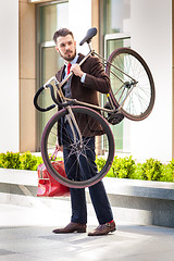 Image showing Handsome businessman carrying his bicycle in his office