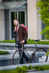 Image showing Handsome businessman and his bicycle