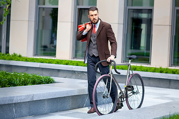 Image showing Handsome businessman and his bicycle