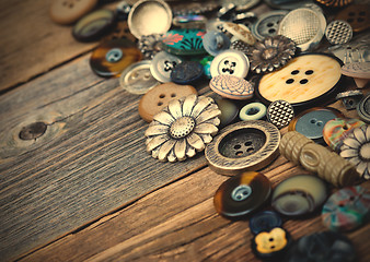 Image showing old buttons in large numbers scattered on aged wooden boards
