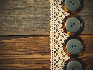 Image showing four vintage buttons and antique lace on ancient boards aged tab