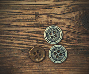 Image showing set of vintage buttons on wooden boards aged antique table. inst