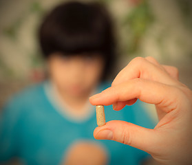 Image showing hand of a  doctor with pill and child