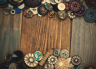 Image showing set of vintage buttons on aged boards of old table