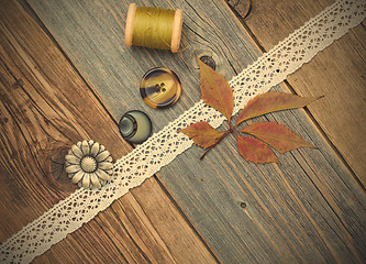 Image showing still life with lace tape, vintage buttons, spools of thread and