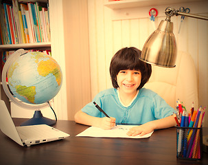 Image showing smiling schoolboy doing homework