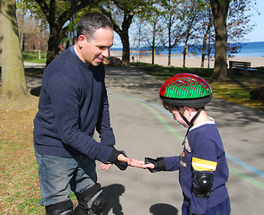 Image showing Father and son rollerblading