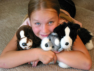Image showing Girl hugging her plush toys