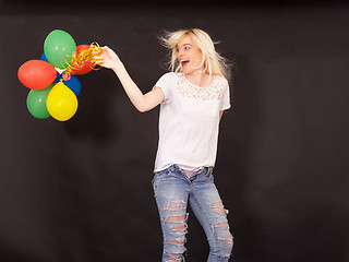 Image showing Young laughing woman with coloured aerial balloons