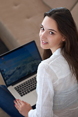 Image showing relaxed young woman at home working on laptop computer