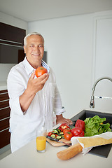 Image showing man cooking at home preparing salad in kitchen