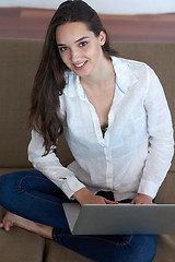 Image showing relaxed young woman at home working on laptop computer