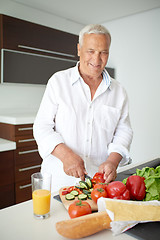 Image showing man cooking at home preparing salad in kitchen