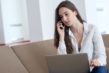 Image showing relaxed young woman at home working on laptop computer