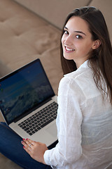 Image showing relaxed young woman at home working on laptop computer