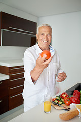 Image showing man cooking at home preparing salad in kitchen