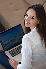 Image showing relaxed young woman at home working on laptop computer