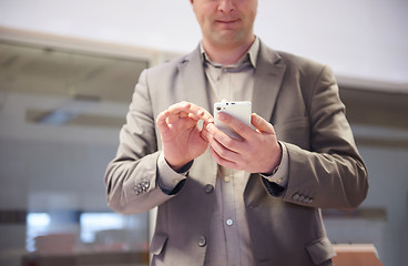 Image showing business man working on phone at office