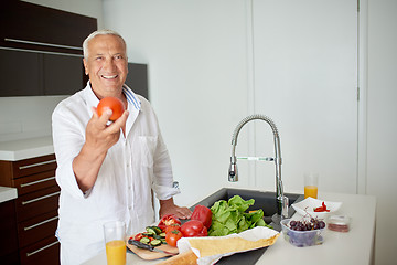 Image showing man cooking at home preparing salad in kitchen