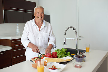 Image showing man cooking at home preparing salad in kitchen