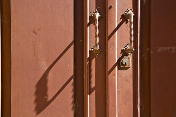 Image showing caidate   varese abstract   brass brown knocker  closed wood lom