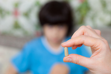 Image showing hand of a  doctor with pill and child