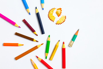 Image showing several colored pencils and shavings on white background with co