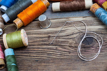 Image showing spool of thread, a thimble and a sewing needle