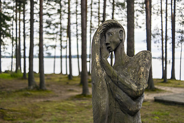 Image showing Wooden idol of woman in forest