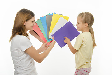 Image showing child shows colors the image in hands of women