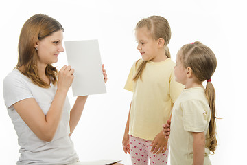 Image showing Mom shows the kids a white sheet of paper