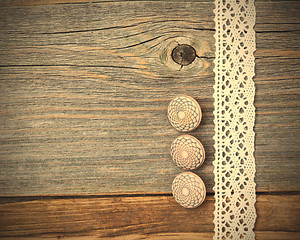 Image showing Three vintage bone buttons and lace tape