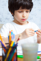 Image showing boy chooses a pencil