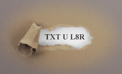 Image showing Text appearing behind torn brown envelop