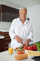 Image showing man cooking at home preparing salad in kitchen