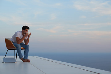 Image showing relaxed young man at home on balcony