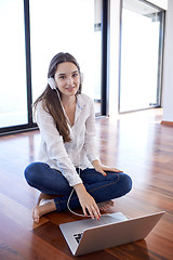 Image showing relaxed young woman at home working on laptop computer