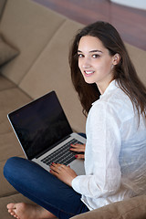 Image showing relaxed young woman at home working on laptop computer