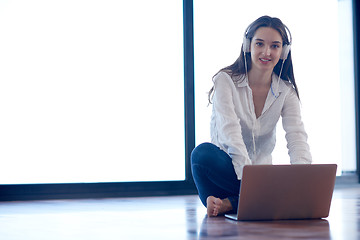 Image showing relaxed young woman at home working on laptop computer