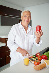 Image showing man cooking at home preparing salad in kitchen