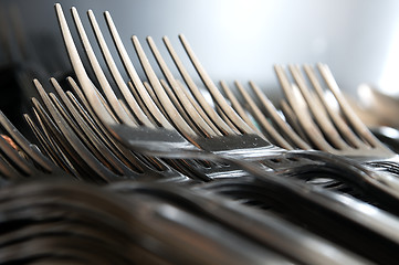 Image showing Forks arranged in series on the kitchen table.