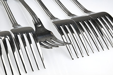 Image showing Forks arranged in series on the kitchen table.